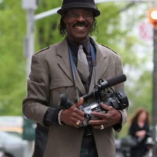 Roman Paul outdoors holding a professional video camera