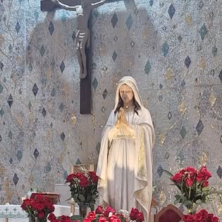 Floral arrangements and a statue inside a church sanctuary